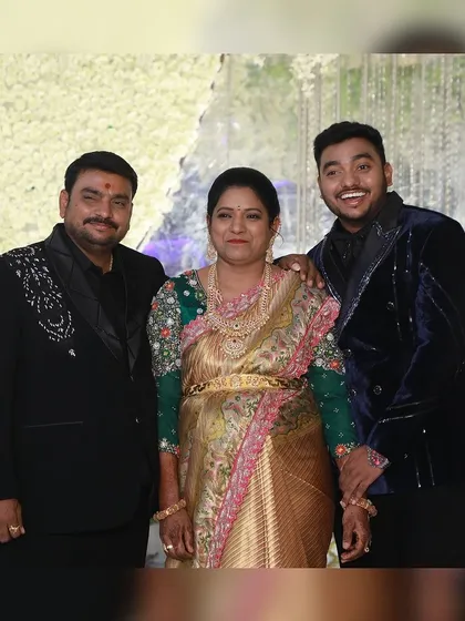 A family celebrating in style. The father and son wear our custom black and blue velvet tuxedos, showcasing our ability to dress the entire family for a reception.