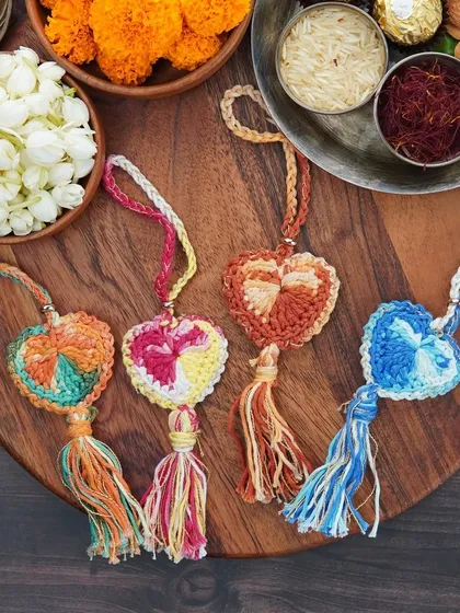My full collection of heart-shaped Lumba rakhis. Each one is made with multi-colored yarn and a tassel, and can be used as a bag charm later.