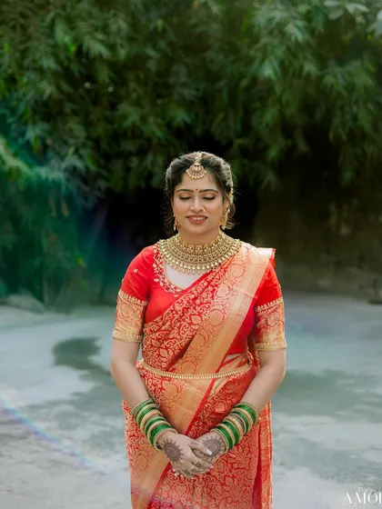 A classic bride in red. This Maharashtrian bride looks timeless in her red and gold saree, with makeup that is elegant, defined, and perfectly balanced.