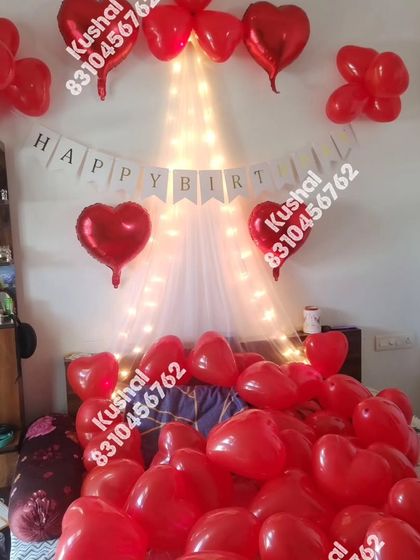 Another view of the romantic bedroom setup, showing the "Happy Birthday" banner and heart foil balloons.