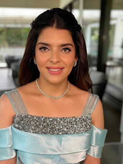 The client looks beautiful and happy with her half-up hairstyle. It's a comfortable yet elegant choice for a post-engagement party.