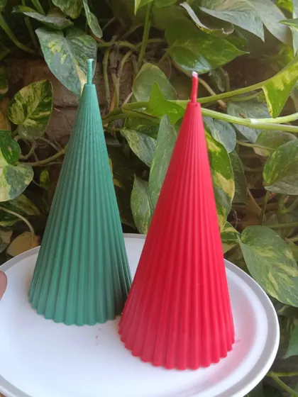 A pair of red and green ribbed Christmas candles.