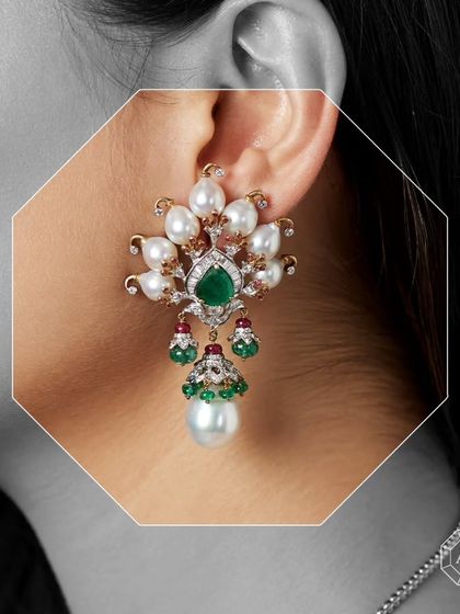 Crafted in 18kt gold, these earrings feature South Sea pearls, sparkling diamonds, African rubies, and Zambian emeralds.