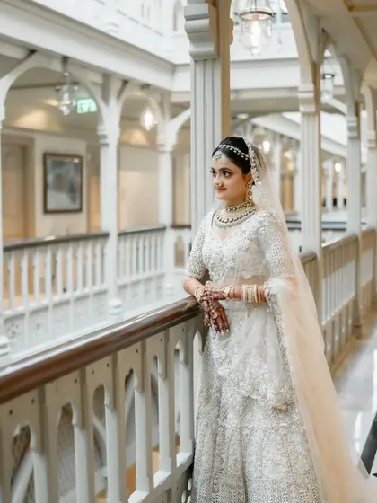 The bride, standing in a majestic heritage corridor, looks like she has stepped out of a royal painting.