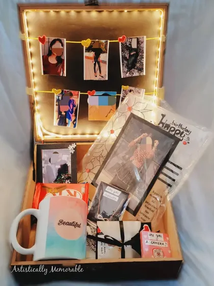 Another view of the birthday hamper, showing the polaroid-style photos hanging on the light-up string.