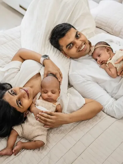 A happy family of four relaxing on the bed. This at-home lifestyle shot with twins is full of joy and natural connection, capturing a perfect family moment.