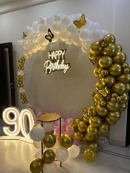 Another view of the elegant 90th birthday decor, showing the delicate butterfly details on the balloon arch.