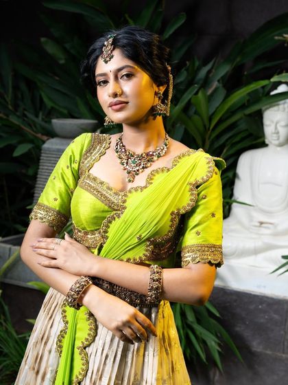Wrapped in elegance, this half saree features a light gold tissue lehenga paired with a vibrant lime green princess katori blouse. The entire ensemble, including the dupatta, is finished with intricate handwork for a look of traditional grace.