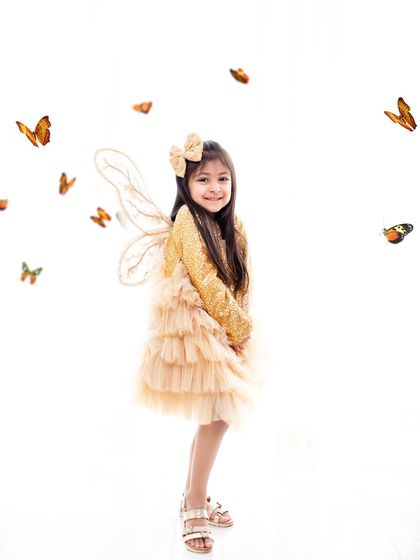 A beautiful butterfly fairy in a simple, elegant setting. The focus is all on her sweet smile and the delicate wings that make the theme come to life.