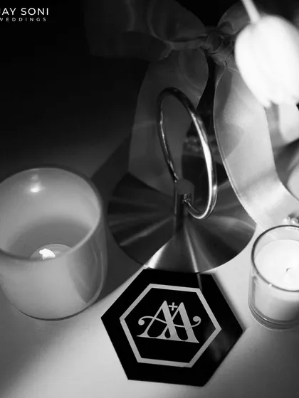 A moody, black and white shot of a custom coaster with the couple's monogram, showcasing the sophisticated branding of the event.