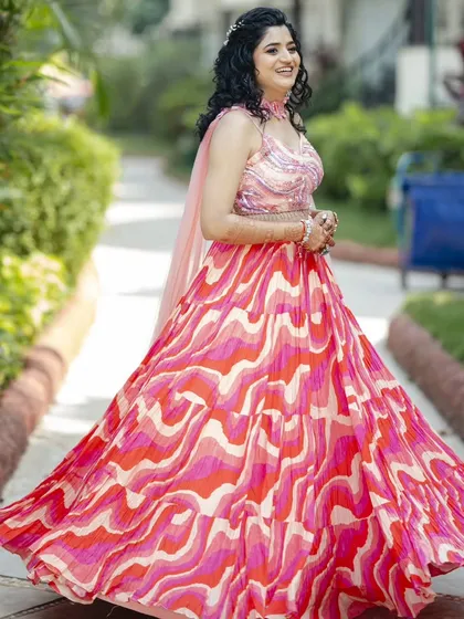 This Haldi hairstyle features natural curls in a half-updo, adorned with a small floral accessory. It's a fun, fresh, and practical style that keeps the hair managed during the ceremony.
