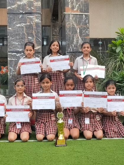 The girls' gymnastics team proudly displays their certificates of participation and achievement. We encourage all our students to participate in competitive events to gain valuable experience and build confidence.