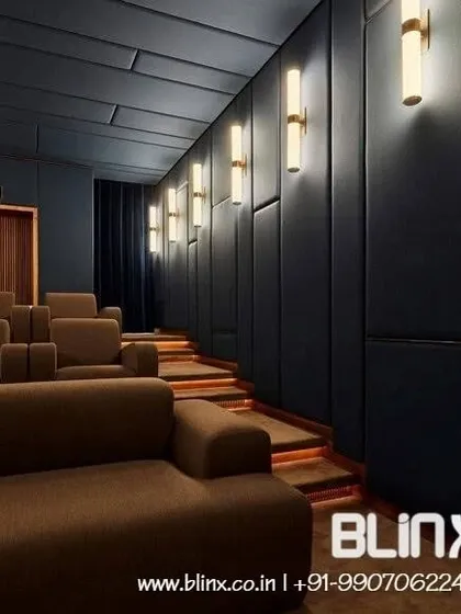 This side view highlights the functional design elements of a multi-row theater. The illuminated steps ensure safe movement in low light, while the dark, fabric-wrapped acoustic panels along the wall are essential for creating a room with balanced and clear sound.