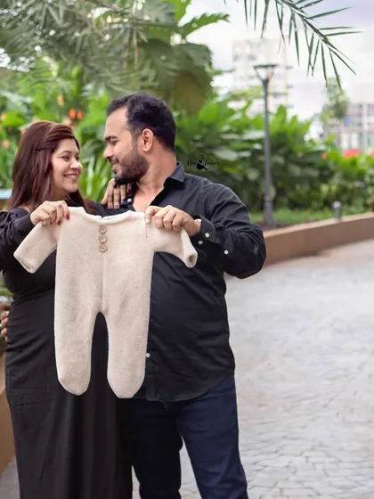 Holding up a tiny baby onesie is a classic and adorable way to announce that you're expecting. The casual outfits make the moment feel relaxed and natural.