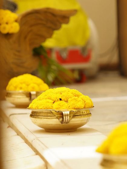 Small brass bowls filled with marigolds, simple yet elegant details that add to the overall aesthetic of the ceremony.
