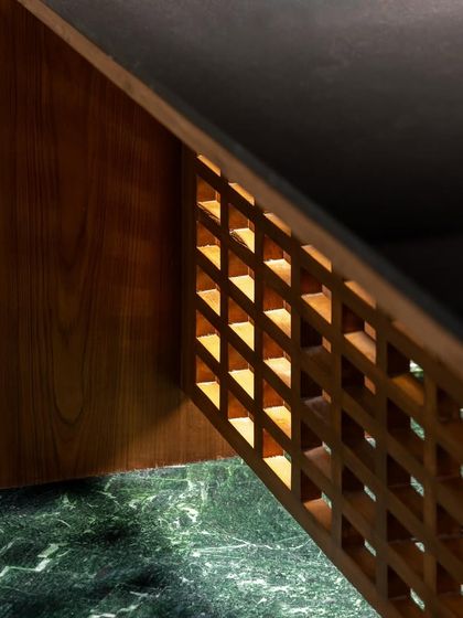 We designed this desk for the Sanctum site office with a built-in light source within its wooden lattice structure. This feature not only provides ambient light but also highlights the intricate craftsmanship of the joinery, turning a functional piece into a design statement.