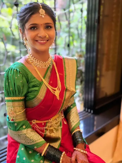 The complete look for my beautiful Maharashtrian bride. Her red and green saree, gold jewelry, and radiant makeup create a picture of timeless elegance.