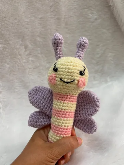 This butterfly stick rattle is designed to be easy for babies to hold. It's made in soft pastel colors and has a gentle rattle sound inside.