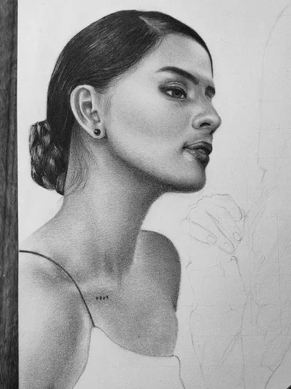 A work-in-progress graphite portrait of actress Diljot Chhabra. This shows the face and hair bun fully rendered with the rest of the sketch still in outline form.