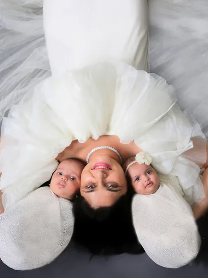 A creative and artistic portrait of a mother with her newborn twins. This overhead shot beautifully frames their faces and highlights the special bond of motherhood.