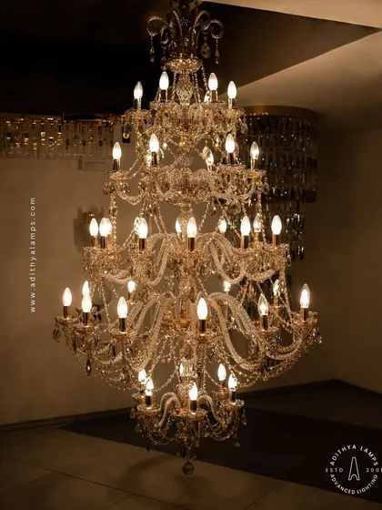 The epitome of luxury, this grand multi-tiered crystal chandelier is designed for double-height spaces. Its cascading crystal beads and classic candelabra bulbs create a dazzling display of light and opulence, perfect for grand entryways and formal living areas.