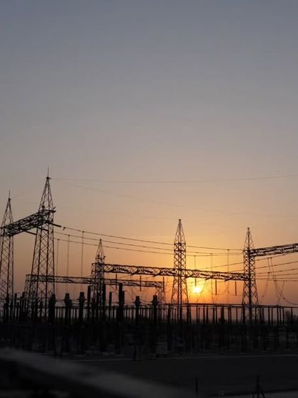 The transmission infrastructure at one of our open-access solar farms, silhouetted against the sunset. We manage the entire process, including grid connectivity and regulatory approvals, to ensure a seamless transition to clean energy for our clients.