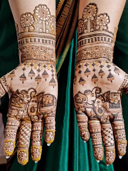 An engagement mehendi with charming elephants on the palms and a depiction of a garden scene on the arms.