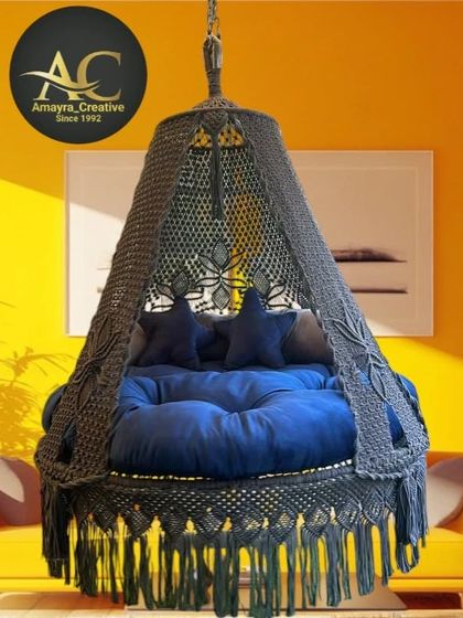 This dark grey bed swing with star-shaped cushions adds a touch of modern style. The floral knot pattern on the canopy is a signature detail of our craftsmanship.