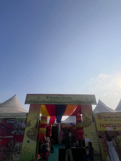 The entrance and ticket counter setup for the Dastkar Bazaar. I ensure these functional areas are clearly marked and organized to handle the flow of visitors efficiently.