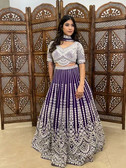 A full-length shot of the purple and silver lehenga, showcasing its unique striped pattern.