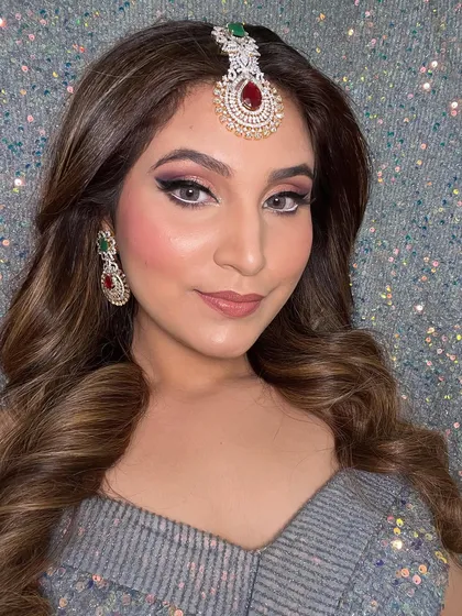 This shot captures the full effect of the dramatic eye makeup and soft waves. It's a confident and bold look for any celebration.