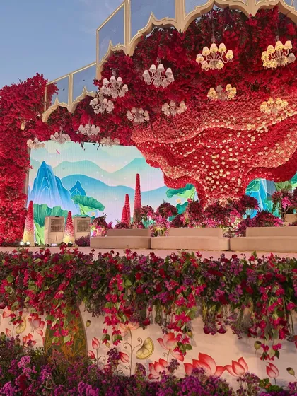 The alchemy of hues is truly unreal. This side view of the stage shows the massive floral installation against a custom-painted mountain backdrop. 🩷💜