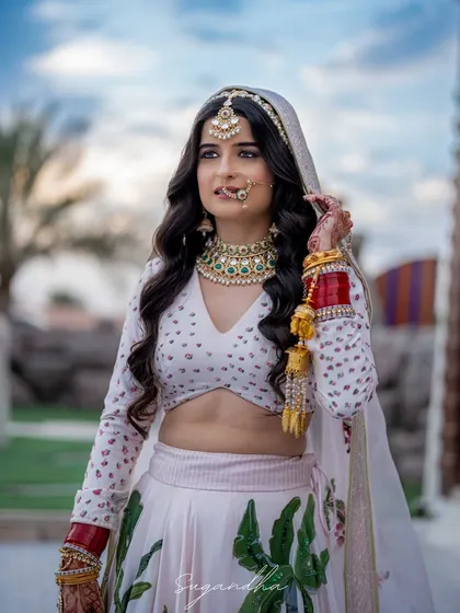 A beautiful portrait of a bride in her unique white and green lehenga. Her traditional jewelry and modern outfit create a stunning fusion look.