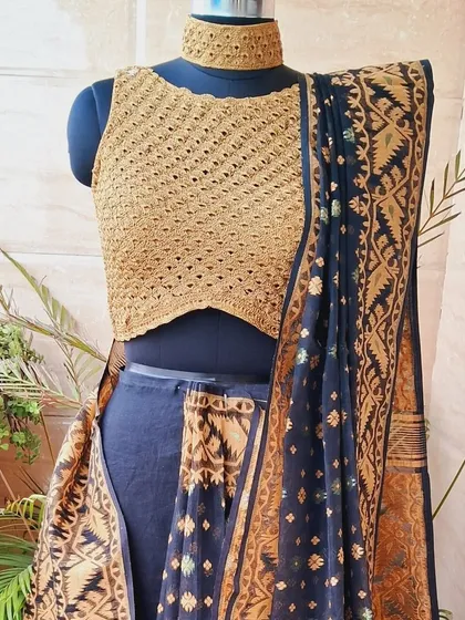 A closer look at our zari yarn crochet blouse, designed to be paired with a traditional saree. The high-neck choker style and intricate stitchwork make it a luxurious and unique choice for festive occasions.