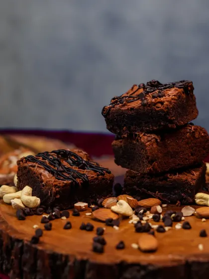 A stacked tower of our nutty brownies. This shot highlights the rich texture and the generous amount of nuts and chocolate chips baked into every piece.