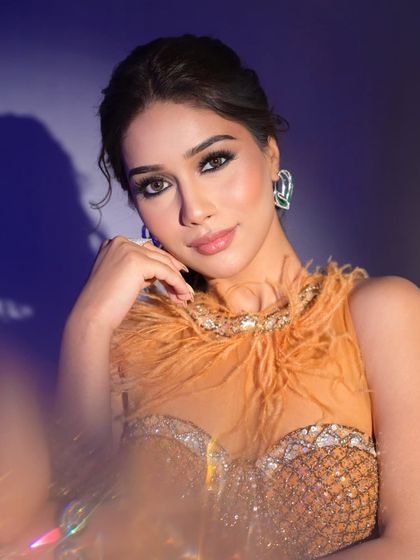 A close-up of the dramatic eye makeup and flawless skin. This look is all about confidence and high-fashion glamour.