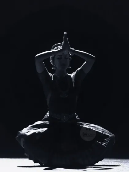 A silhouette created by dramatic backlighting. This photo highlights the form and posture of the dancer, creating a powerful, almost spiritual image.
