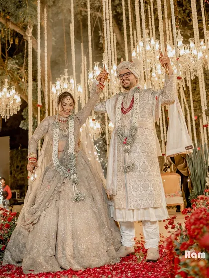 Capturing the scale and beauty of a luxury wedding is key. Here, the couple stands amidst a stunning decor of hanging chandeliers and a carpet of red rose petals, showcasing my ability to frame both the couple and the grandeur of their celebration in one epic shot.