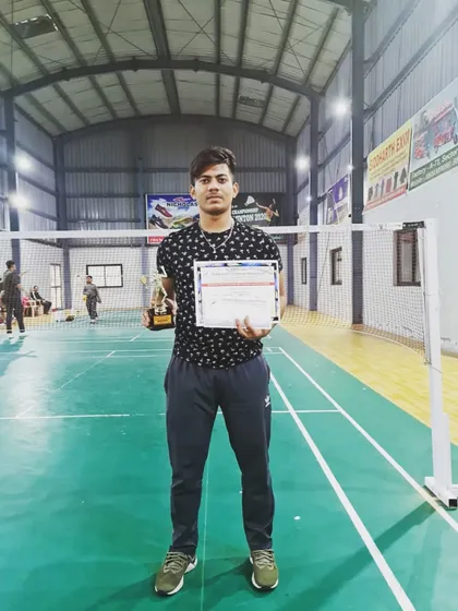 Himanshu Negi with his trophy and certificate after securing a bronze medal in the Mixed Doubles category at the UP State Badminton Championship.