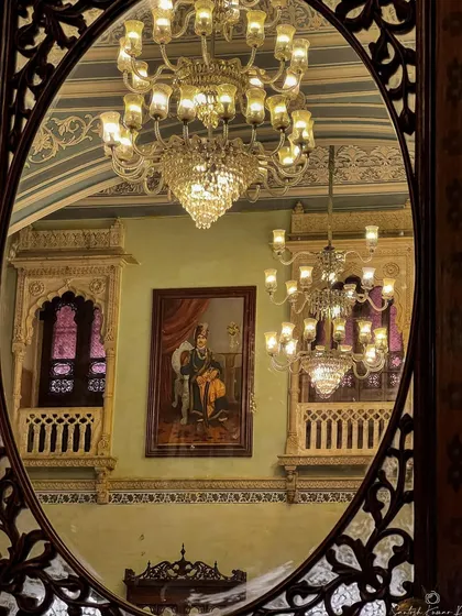 A reflection in an antique mirror reveals the opulent interior of a Rajasthani palace. This shot plays with perspective, capturing the history, art, and grandeur of India's royal past.