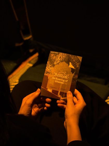 A guest holds the program for an evening of ghazals. It’s these little details that make the experience special, setting the tone for a night of beautiful music.
