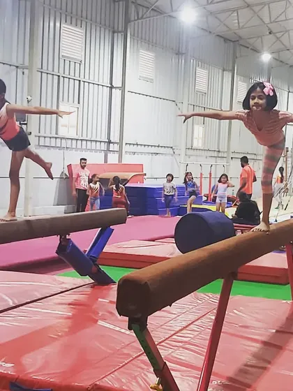 In my classes, students learn focus and discipline while also encouraging each other. Here, two young gymnasts practice their balance and form on the beams during a group session.