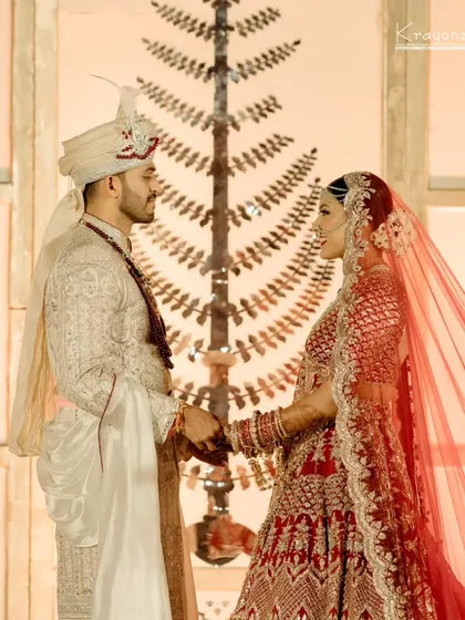 A classic portrait of the bride and groom, holding hands and sharing a quiet moment of connection amidst the wedding celebrations.