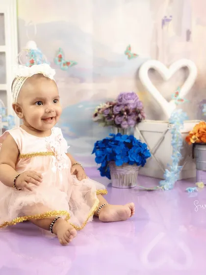 A happy, relaxed portrait from a 6-month milestone session. The soft colors and floral details create a dreamy, whimsical feel.