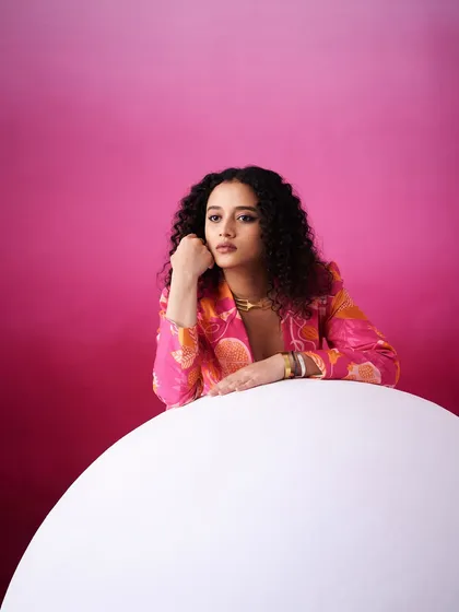 A more pensive fashion portrait. The subtle makeup and natural hair texture work well with the modern, graphic styling of the shot.