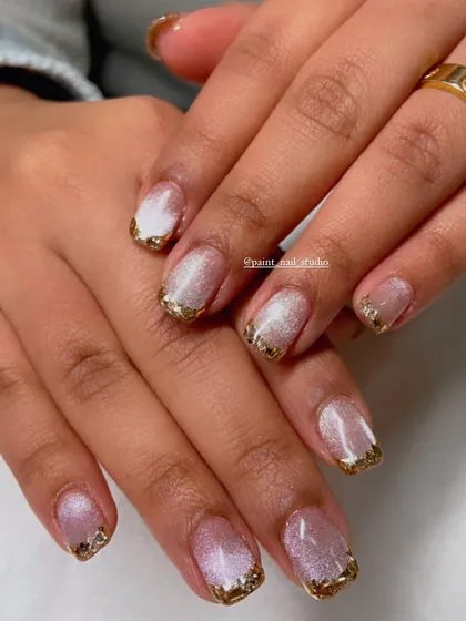 A glamorous look for shorter, square-shaped nails. This design features a cat-eye base with a chunky, textured gold glitter tip.