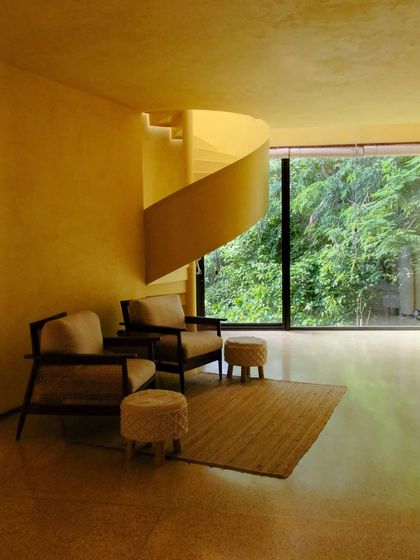 The living area of the Banyan Suite, featuring a spiral staircase and comfortable seating, designed for groups to gather or find their own quiet space.