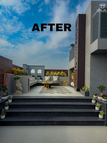 This "after" shot showcases the dramatic, multi-level terrace design. The illuminated stairs lead up to a chic lounge area with custom planters and architectural details.