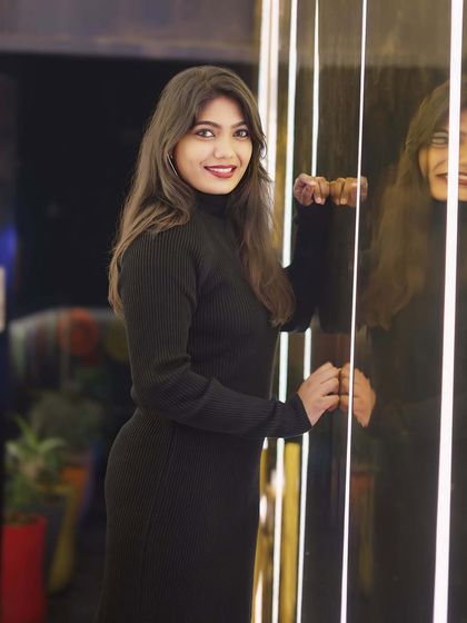 A guest posing against a reflective, lit-up wall.