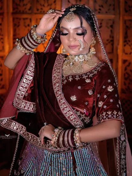 A serene portrait with the bride's eyes closed, focusing on the makeup and the details of her attire.